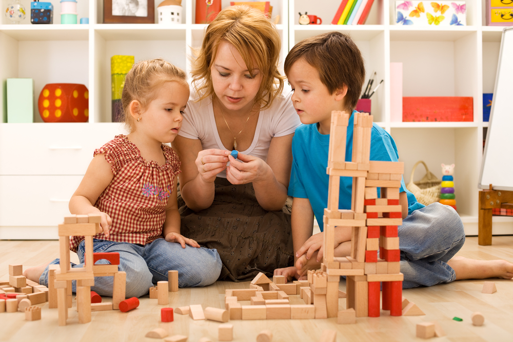 Mom helping the kids learn through play with blocks